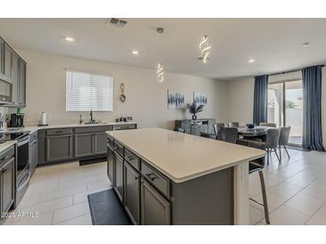 Modern kitchen with stainless steel appliances, gray cabinets, and a center island at 2775 N Mulberry Pl, Casa Grande, AZ 85122