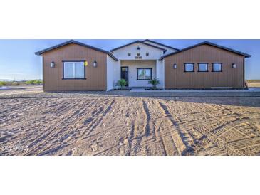 Charming single-story home featuring a low-pitched roof, a landscaped yard, and a welcoming front entrance at 3033 N 367Th Ave, Tonopah, AZ 85354