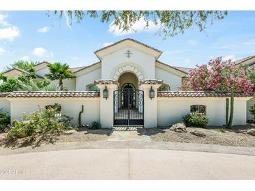 Elegant home featuring a gated entrance and lush landscaping, creating a welcoming approach at 7003 E Avenida El Alba --, Paradise Valley, AZ 85253
