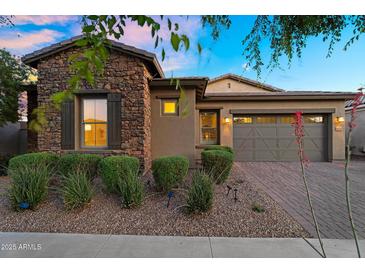 Beautiful single-story home with stone accents, manicured landscaping, and a charming paver driveway at 10741 E Palladium Dr, Mesa, AZ 85212