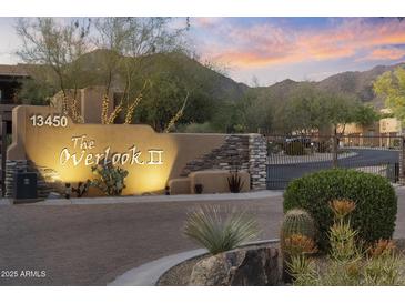 Elegant community entrance featuring desert landscaping, stone accents, and well-lit signage at sunset at 13450 E Via Linda -- # 2041, Scottsdale, AZ 85259