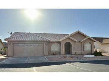 Charming single-story home with a tile roof, arched entryway, and well-maintained front yard landscaping at 6942 S Championship Dr, Chandler, AZ 85249