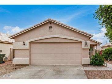 A well-maintained garage features a neutral color scheme and a clean concrete driveway under a bright blue sky at 10407 W Reade Ave, Glendale, AZ 85307