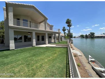 View of the home's backyard, featuring a lush lawn and waterfront access at 1414 N Palmsprings Dr, Gilbert, AZ 85234
