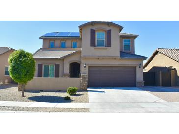 Inviting home features a two-car garage, desert landscaping, and solar panels at 17829 W Sherman St, Goodyear, AZ 85338