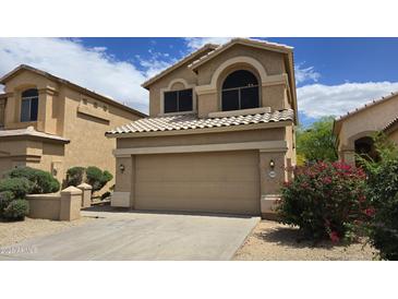 Charming two-story home featuring a two-car garage and a well-maintained desert landscape under a sunny sky at 1909 N 106Th Ave, Avondale, AZ 85392