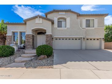 Charming two-story home featuring a three car garage, stone accents, and lovely landscaping at 4490 S Rio Dr, Chandler, AZ 85249