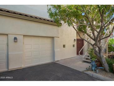 Inviting condo exterior featuring a private garage, entry staircase, and mature desert landscaping at 9750 N Monterey Dr # 21, Fountain Hills, AZ 85268