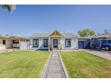 Charming single-story home with beautiful green lawn, stone pathway, and painted accents at 1422 E Windsor Ave, Phoenix, AZ 85006