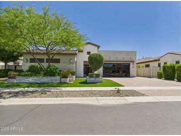 Stunning single-story home with lush landscaping, modern design, and a spacious driveway at 4571 S Pinaleno W Dr, Chandler, AZ 85249