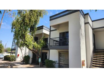 A clean two-story condo with a balcony, green tree, black railings, and a staircase at 740 W Elm St # 264, Phoenix, AZ 85013