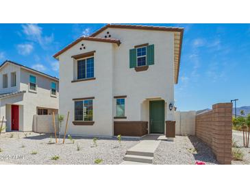 Two-story home with a white exterior, complemented by brown trim, green door and landscaping on a sunny day at 15622 S 181St Dr, Goodyear, AZ 85338