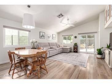 Bright living room featuring wood floors, neutral decor, and a sliding glass door to the backyard at 3269 E San Remo Ave, Gilbert, AZ 85234