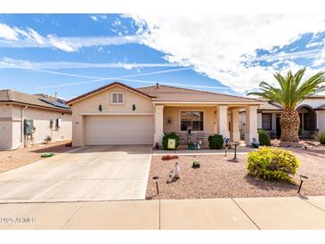 Charming single-story home with stucco siding, tile roof, desert landscaping, and covered front porch at 18031 W Udall Dr, Surprise, AZ 85374