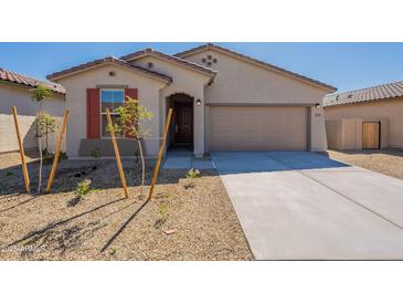 Charming single-story home featuring desert landscaping, a two-car garage, and a welcoming front entrance at 2205 S 241St Dr, Buckeye, AZ 85326