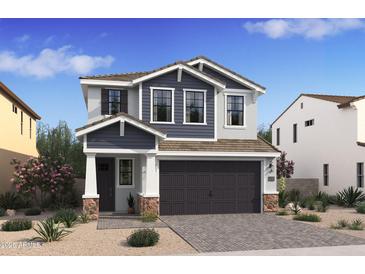 Charming two-story home with gray and white siding, complemented by a spacious two-car garage and a landscaped front yard at 2381 W Los Arboles Pl, Chandler, AZ 85224