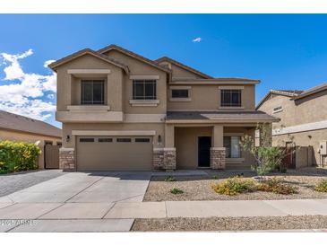 Two-story home featuring a two-car garage, desert landscaping, and a welcoming covered porch at 396 S 166Th Dr, Goodyear, AZ 85338