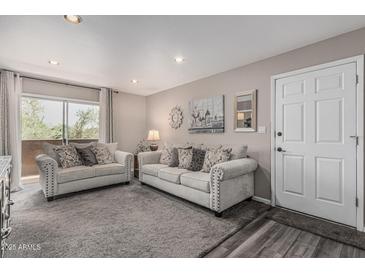 Comfortable living room featuring a gray sofa set, carpeted floors, and access to an outdoor balcony at 5877 N Granite Reef Rd # 2240, Scottsdale, AZ 85250