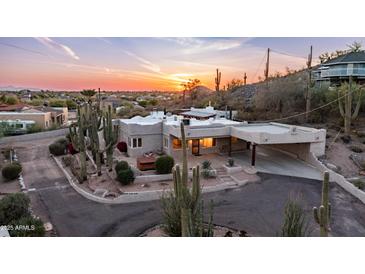 An eye-level exterior featuring Southwestern architecture, desert landscaping, and a sunset background at 612 N Signal Butte Rd, Mesa, AZ 85207