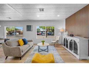 Modern living room featuring stylish furnishings, wood accent wall, and bright natural light at 7836 E Juanita Ave, Mesa, AZ 85208