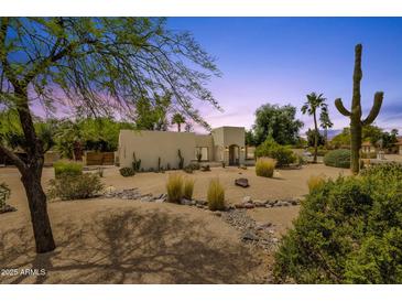 Stunning desert landscaping surrounds the unique exterior of this single-story home at 13034 N 69Th St, Scottsdale, AZ 85254