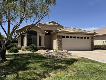Charming single-story home featuring a well-manicured lawn and a two-car garage at 1424 W Mead Dr, Chandler, AZ 85248