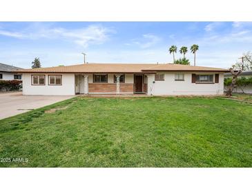 Charming single-story home with a well-maintained lawn, a stone accent, and a welcoming facade at 1431 E 1St St, Mesa, AZ 85203