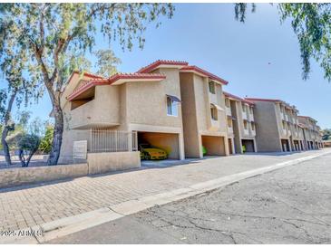 View of the condos with personal carport spaces under the units and red tile roofing at 151 E Broadway Rd # 206, Tempe, AZ 85282