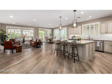 Bright, open-concept living space featuring a modern kitchen island and comfortable seating area at 1804 E Sattoo Way, Queen Creek, AZ 85140