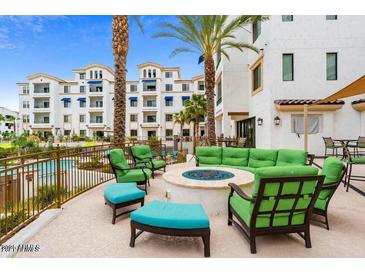 Relaxing outdoor lounge area with a cozy fire pit and pool access, surrounded by lush landscaping and resort style living at 2511 W Queen Creek Rd # 244, Chandler, AZ 85248