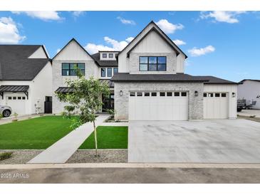 Stunning two-story home featuring a pristine lawn and a three-car garage with a light brick exterior at 26655 S 169Th Pl, Queen Creek, AZ 85142