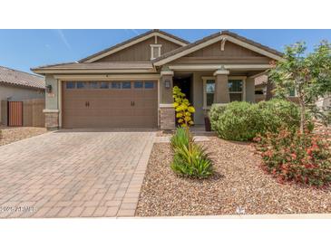 Charming single-story home features a brick driveway, two-car garage, and a beautifully landscaped front yard at 686 N 152Nd Dr, Goodyear, AZ 85338