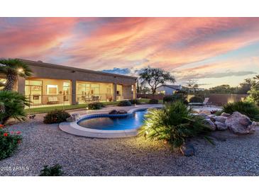 Resort-style backyard featuring a free-form pool, beautiful desert landscaping, and a covered patio, perfect for entertaining at 7848 E Parkview Ln, Scottsdale, AZ 85255