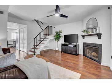 Inviting living room featuring a fireplace, ceiling fan, and staircase to the second floor at 7977 W Wacker Rd # 134, Peoria, AZ 85381