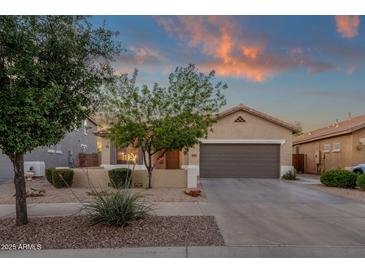 Charming single-story home with manicured front yard and two-car garage under a colorful dusk sky at 20848 E Desert Hills Blvd, Queen Creek, AZ 85142