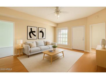 Bright living room features neutral decor, a large window, and modern furnishings for a cozy, inviting space at 8140 N 107Th Ave # 107, Peoria, AZ 85345