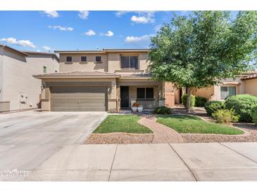 Charming two-story home boasts a manicured lawn and inviting covered porch, perfect for relaxing outdoors at 1518 W Crape Rd, San Tan Valley, AZ 85140