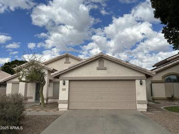 Charming single-story home featuring a neutral color palette, a two-car garage and minimal landscaping at 1704 E Redfield Rd, Gilbert, AZ 85234