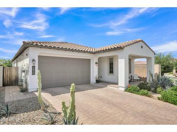 Charming single-story home featuring a tile roof, stucco exterior, and brick-paved driveway and walkway at 1876 S Huish Dr, Gilbert, AZ 85295