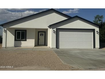 Inviting single story home featuring a two-car garage, gravel landscaping, and modern black trim at 4116 E Park St, Phoenix, AZ 85042