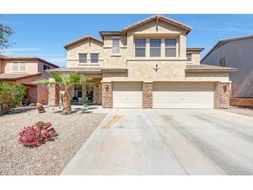 Spacious two-story home featuring a three-car garage, desert landscaping, and a well-maintained lawn at 4138 N 298Th Ln, Buckeye, AZ 85396