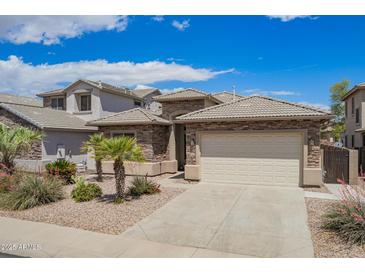 Charming single-story home features a two-car garage and decorative stone exterior at 43828 W Roth Rd, Maricopa, AZ 85138