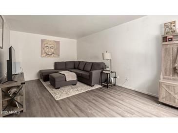 Inviting living room with a comfortable gray sectional sofa, ottoman, and stylish decor at 520 N Stapley Dr # 181, Mesa, AZ 85203
