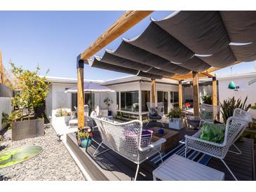 Inviting backyard with multiple seating areas, mature landscaping, and a pergola for shade at 6314 N 14Th St, Phoenix, AZ 85014