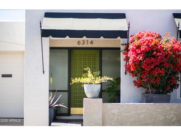 Inviting front entrance with a unique olive door and beautiful bougainvillea bush at 6314 N 14Th St, Phoenix, AZ 85014