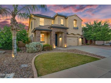 Charming two-story home showcasing well-manicured landscaping and inviting stone accents at 880 E Wimpole Ave, Gilbert, AZ 85297