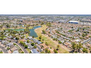 High aerial view of the community showcasing lush green spaces, a lake, and residential areas at 11627 S Jokake St, Phoenix, AZ 85044