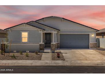 Charming single-story home with a well-manicured front yard and a two-car garage at 37111 W Parador Ln, Maricopa, AZ 85138