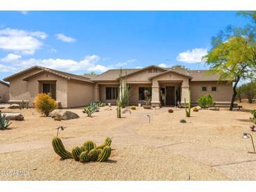 Charming desert landscaping adorns the front yard of this home with stucco exterior and covered porch at 5744 E Hedgehog Pl, Scottsdale, AZ 85266