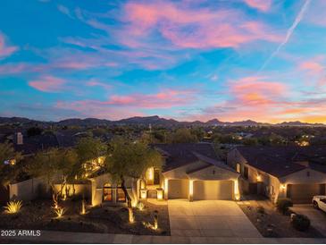 Breathtaking aerial view of the home showcasing the neighborhood, mountain views and colorful sunset at 12428 S 179Th Ln, Goodyear, AZ 85338